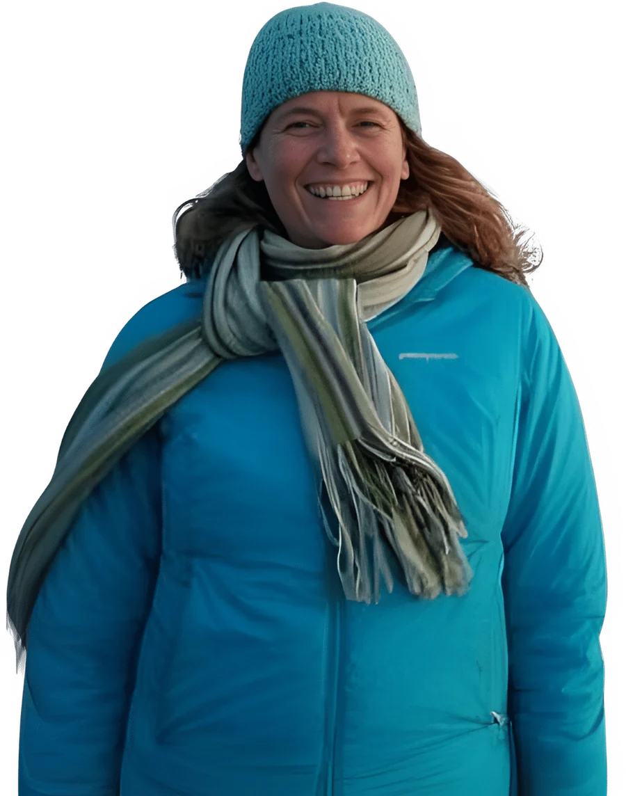 Anna Switzer outdoors in winter, in a teal jacket, knit hat and scarf